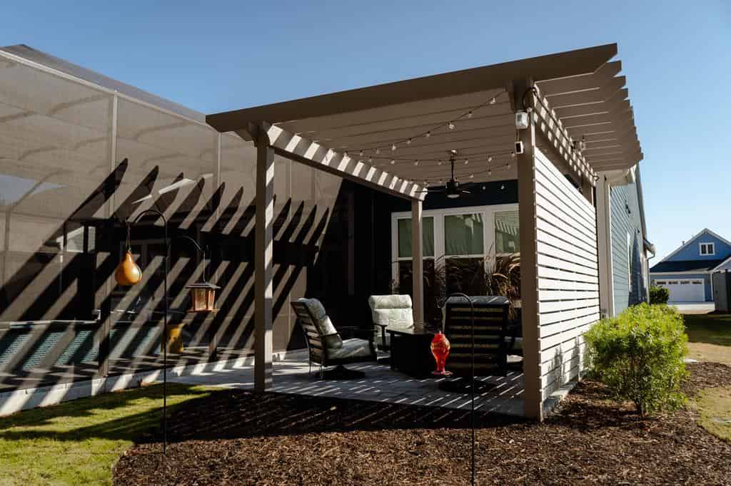 Modern outdoor living space with fire features and pool overlooking a Lowcountry backyard