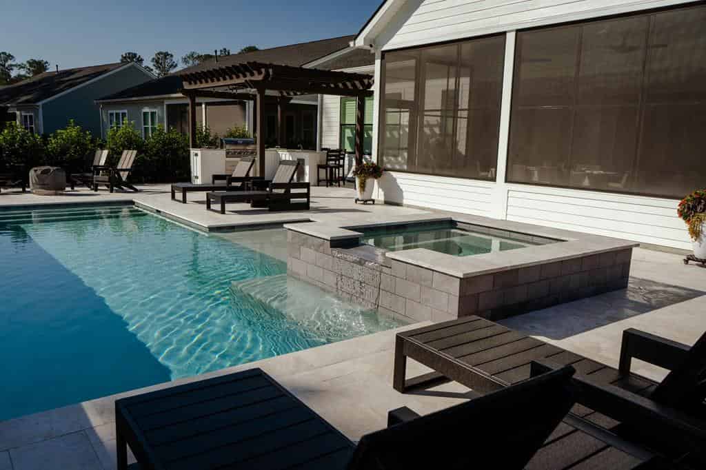 Luxury custom pool and spa at night with ambient lighting in a Lowcountry backyard